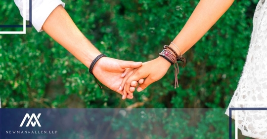 holding hands in front of greenery