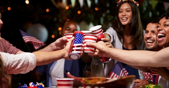 Group clinking glasses at Fourth of July party