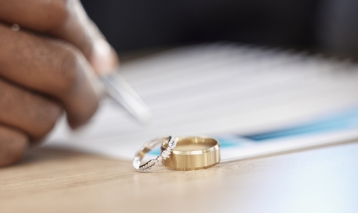 hand signs papers next to wedding rings