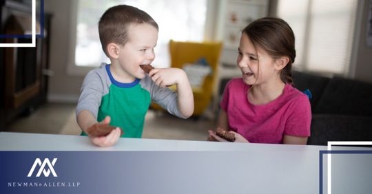 two kids smiling looking at each other while sitting at home