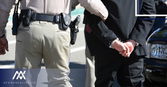 police officer walking with man in handcuffs