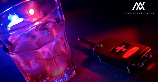 glass with police lights shining through and car keys to the side