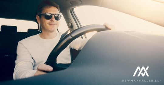 man wearing sunglasses driving a car
